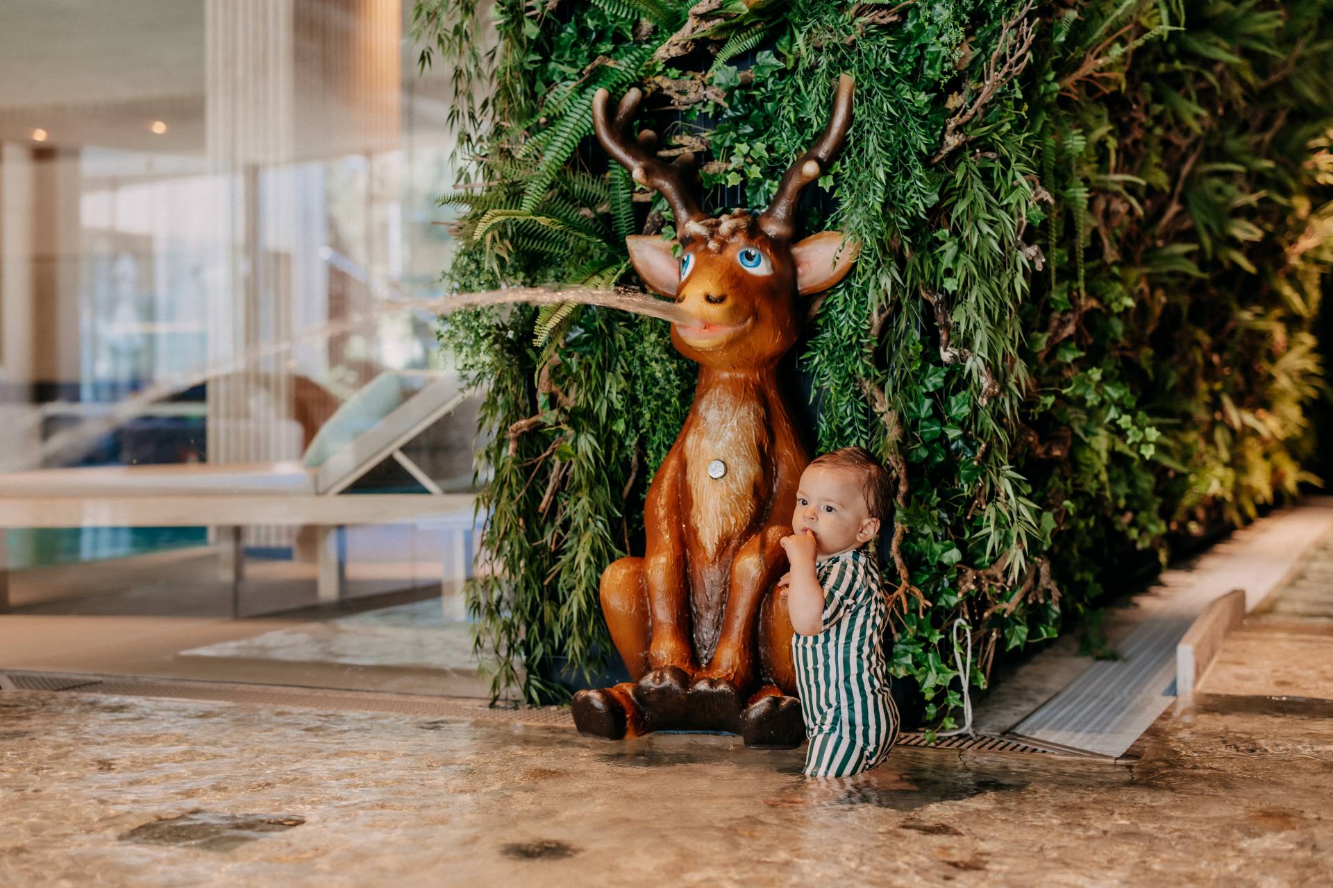 Baby beim Spielen im Wasser im Naturhotel Forsthofgut