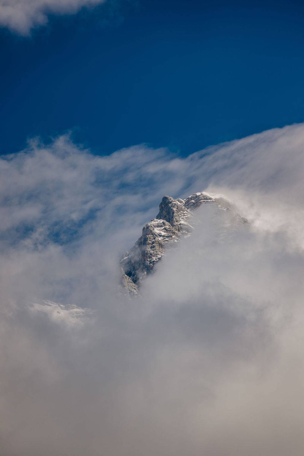 Schneebedeckter Berggipfel in Wolkenwand - Natur i