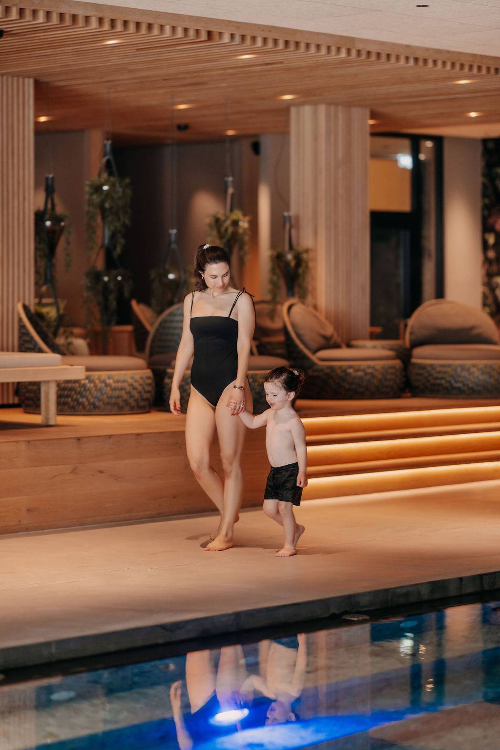 Mother and child sitting on the jetty and enjoying the view of the Steinberge mountains