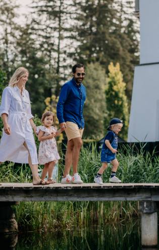 Familie läuft über Steg im Naturhotel Forsthofgut in Österreich