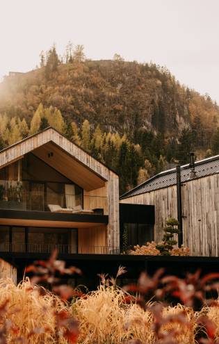 Garden Loft Suites at Naturhotel Forsthofgut, framed by autumn mountain forest and soft evening light.