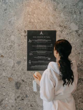 Frau liest Anleitung zum Onsen Ritual im Naturhotel Forsthofgut