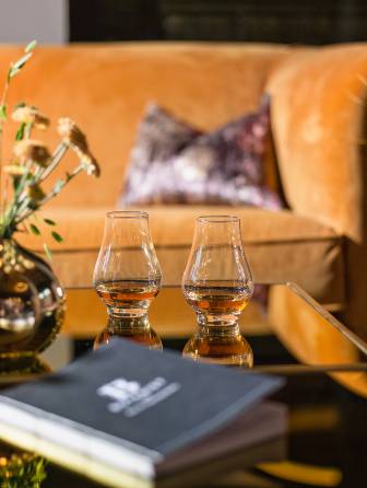 Mann liest Zeitung in Sessel Cocktailbar Naturhotel Forsthofgut