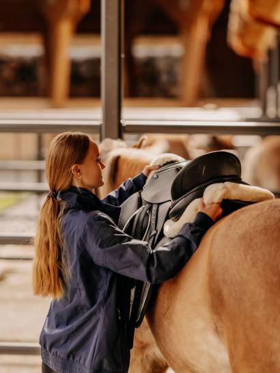 Reiturlaub in Leogang - Frau sattelt Pferd