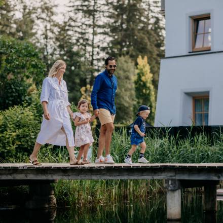 Family walking over a bridge at the Naturhotel Forsthofgut Austria