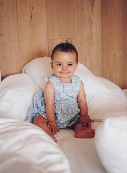 Baby sits in bed