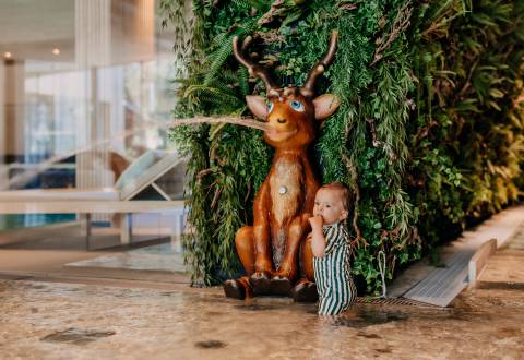 Baby beim Spielen im Wasser im Naturhotel Forsthofgut
