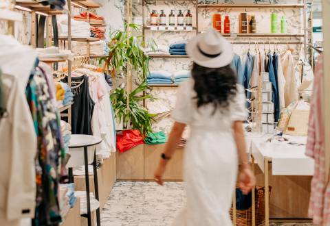 Frau mit weißem Kleid geht durch die lieblingsDINGE Boutique