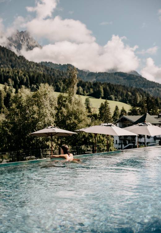 Frau im Sportpool mit Blick auf die Leoganger Steinberge im Naturhotel Forsthofgut