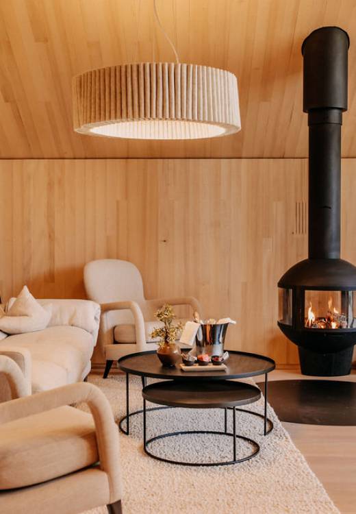 Moderne Suite mit gemütlichem Wohnraum und Kaminstelle im Naturhotel Forsthofgut