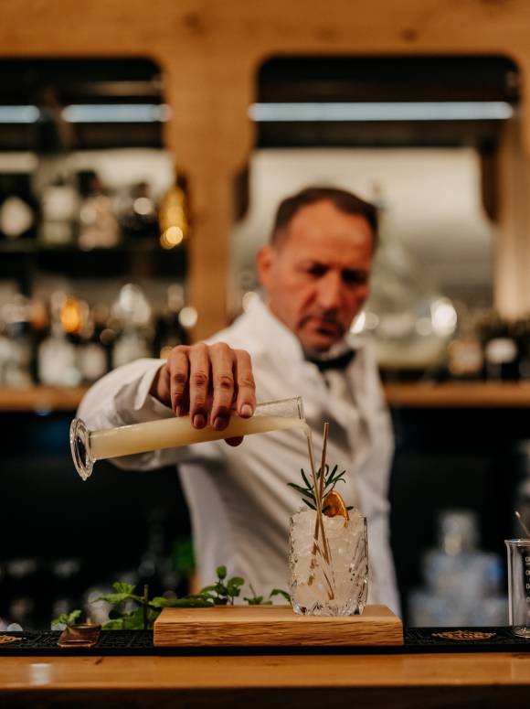Barkeeper mixt ein Drink an der Cocktailbar Botanist in Leogang