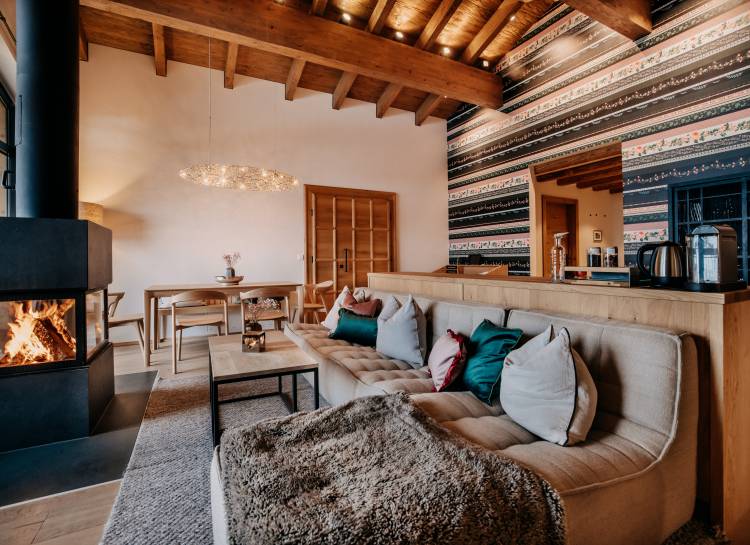 Chalet Suite Landleben mit Couch und Kamin im Naturhotel Forsthofgut