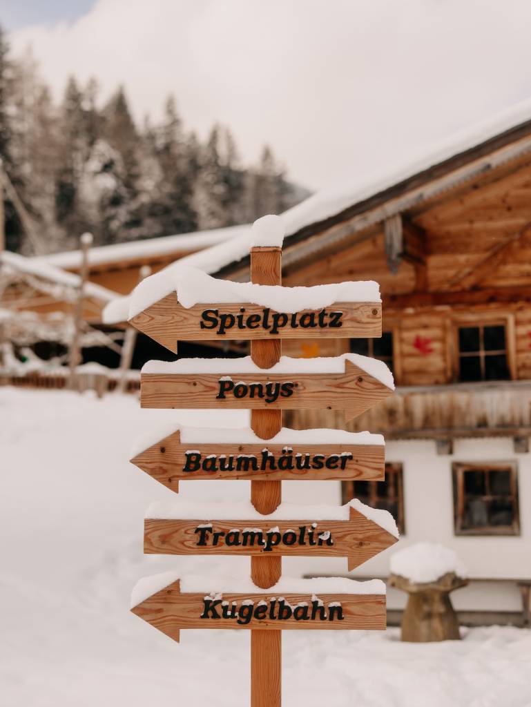 waldspielplatz mit Holzgeräten, Rutschen und einer Murmelbahn im Forsthofgut