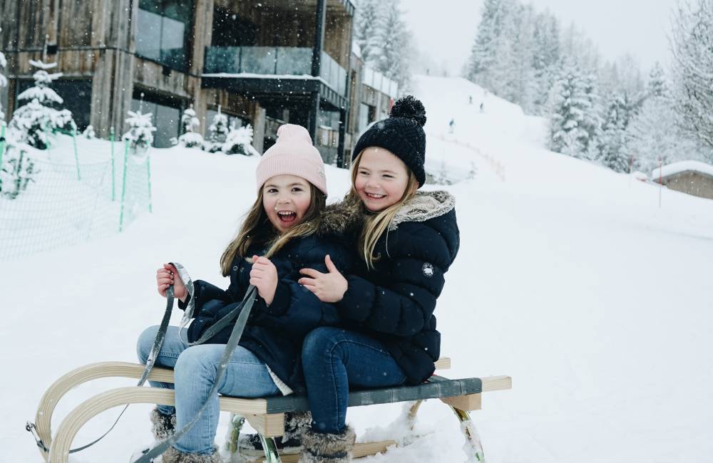 Children tobogganing snow winter holidays Austria Leogang