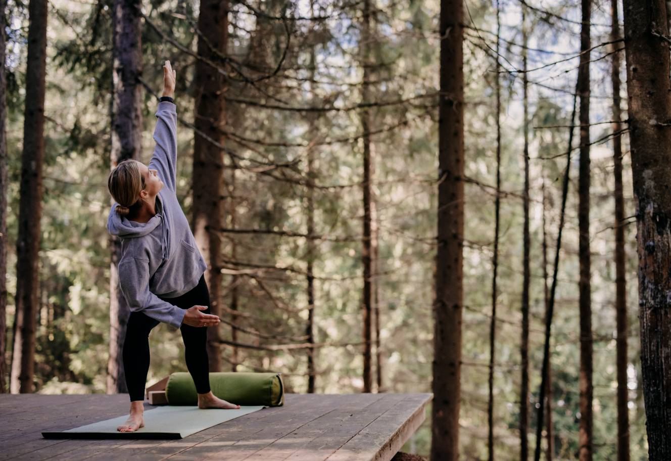 Yoga retreat in the Forsthofgut - Woman practicing yoga in forest