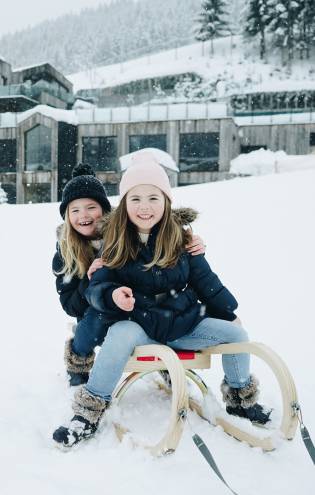 Kinder auf Schlitten im Winter