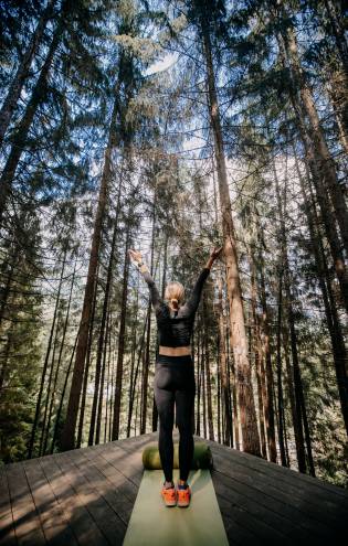 Woman practices yoga in the forest