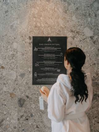 Woman reads the instruction of the Onsen ritual