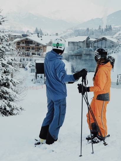 Skifahrer stehen auf der Piste zum Naturhotel Forsthofgut im Winter