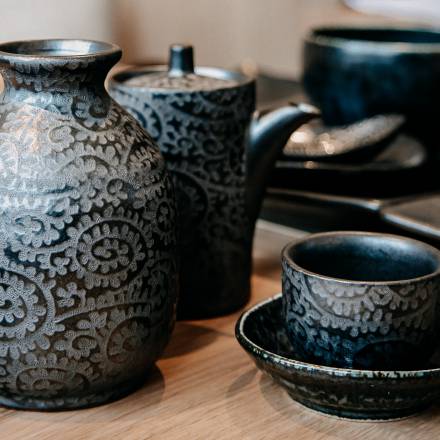 Keramik Krüge und Kannen für Sake auf Holztisch im Seerestaurant Mizumi