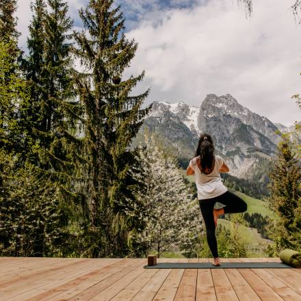 Entspannung im Sommerurlaub - Frau macht Yoga im Wald