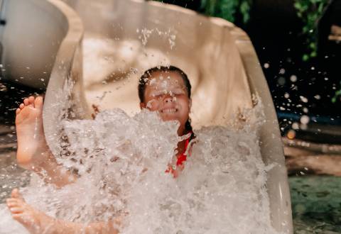 Child slides down the slide in the waldSPA