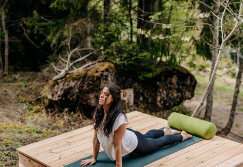 Frau beim Yoga im Wald in Leogang