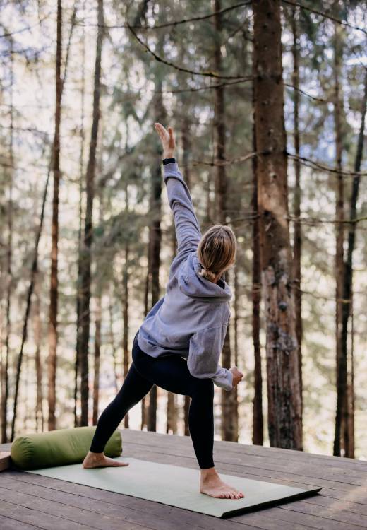 Yoga Auszeit - Frau praktiziert Yoga im Wald