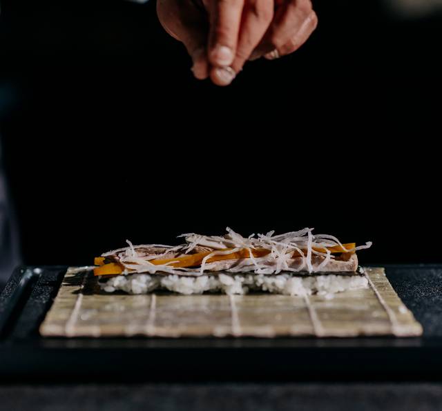 Shushi Meister bereitet Inside-Out Roll Sushi vor