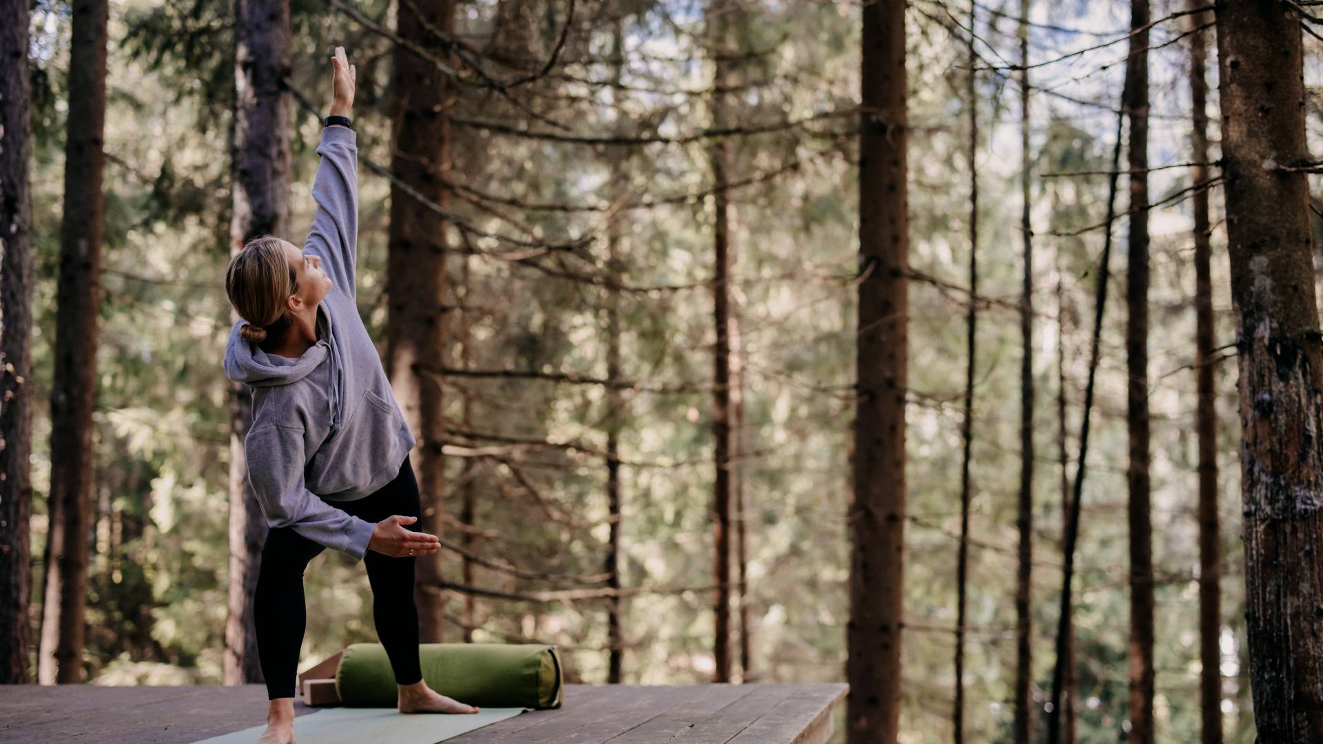 Frau praktiziert Yoga im Wald