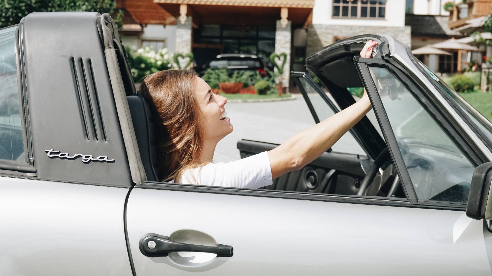 Frau sitzt im Porsche Targa Cabriolet