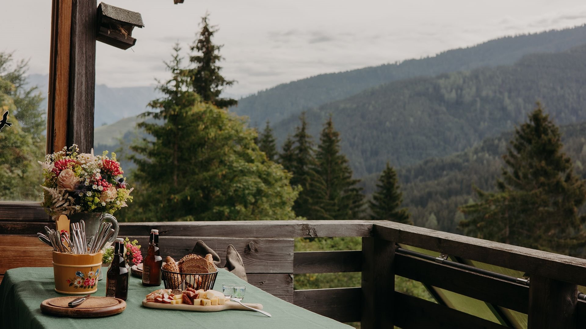 Gedeckter Tisch auf der Terrasse der Thoman Alm – mit weitem Blick über Wiesen und Wälder.