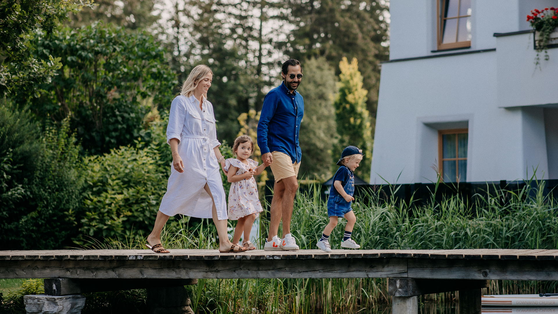 Familie beim gemeinsamen Spaziergang am Steg des Naturteichs im Forsthofgut.
