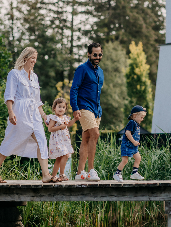 Familie beim gemeinsamen Spaziergang am Steg des Naturteichs im Forsthofgut.
