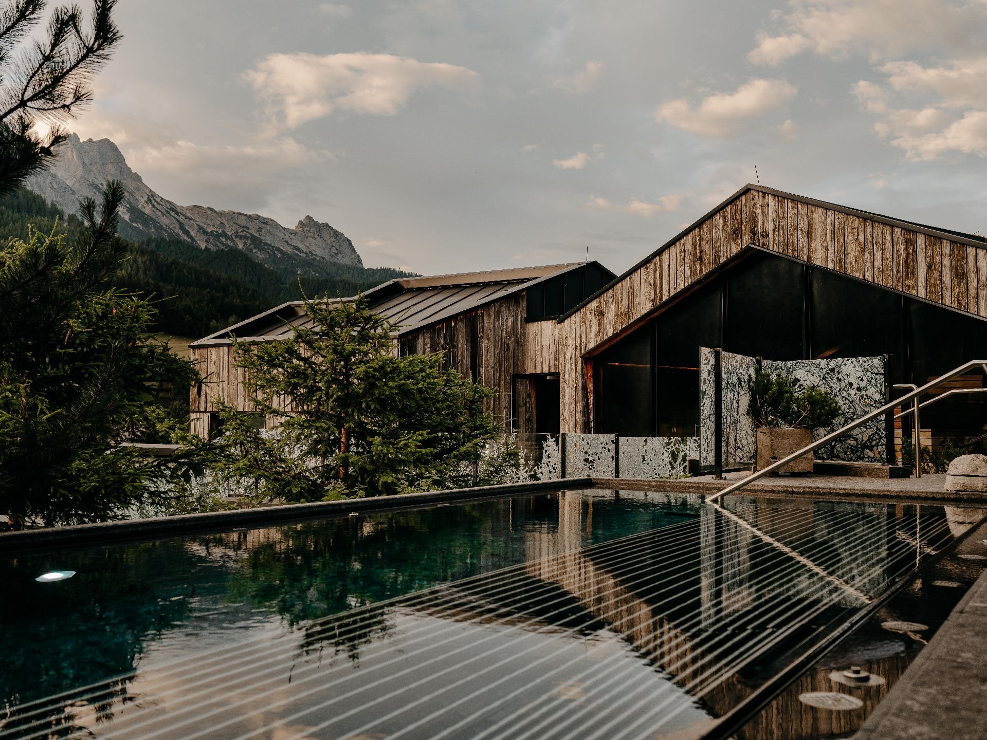 Ruhige Poollandschaft im WaldSPA des Naturhotel Forsthofgut in Leogang, umgeben von Natur und Salzburger Bergpanorama.