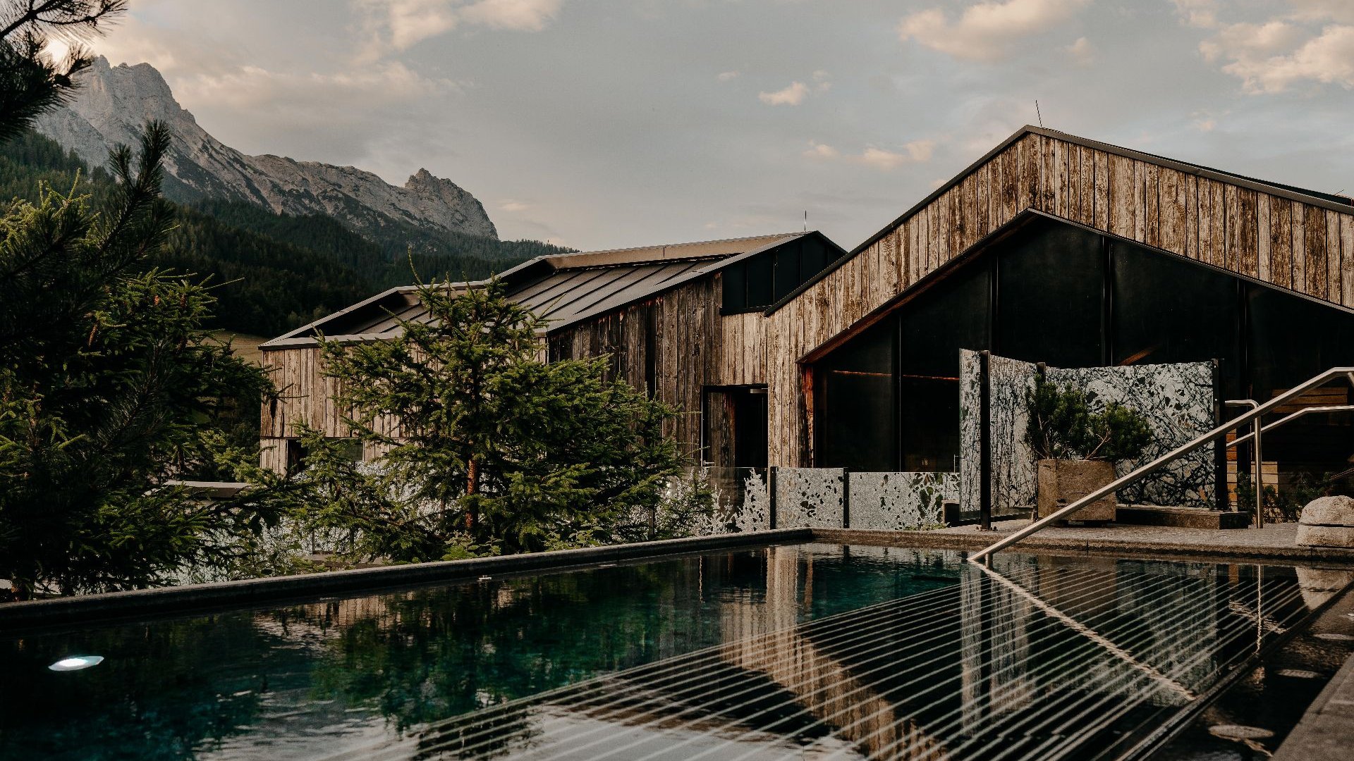 Ruhige Poollandschaft im WaldSPA des Naturhotel Forsthofgut in Leogang, umgeben von Natur und Salzburger Bergpanorama.