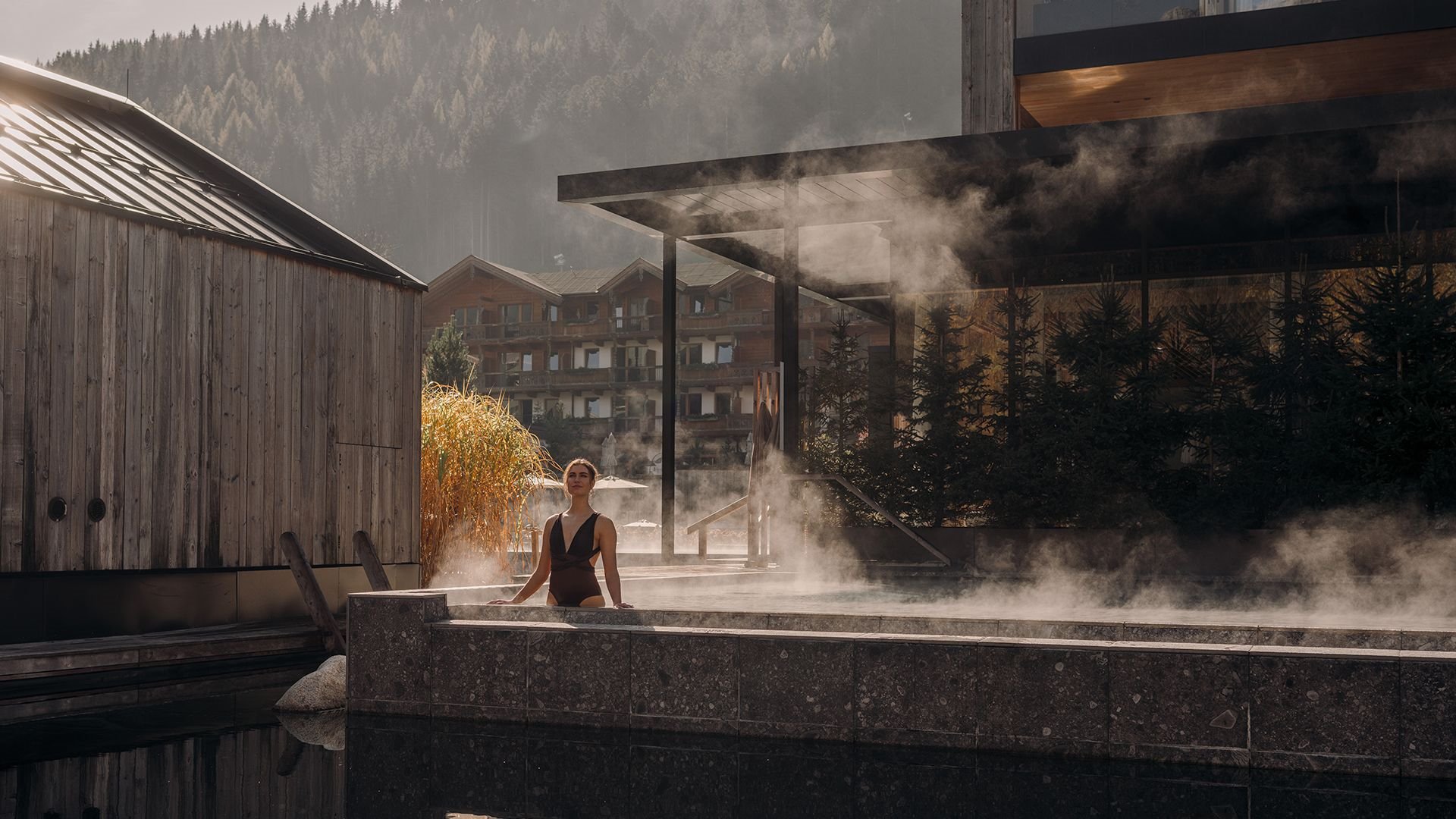 Guest enjoying the calm atmosphere in the warm lake pool at Naturhotel Forsthofgut.