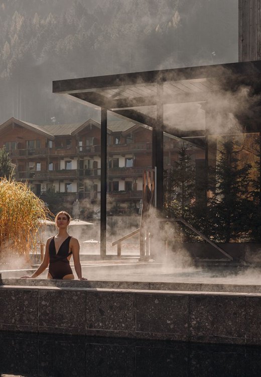 Guest enjoying the calm atmosphere in the warm lake pool at Naturhotel Forsthofgut.