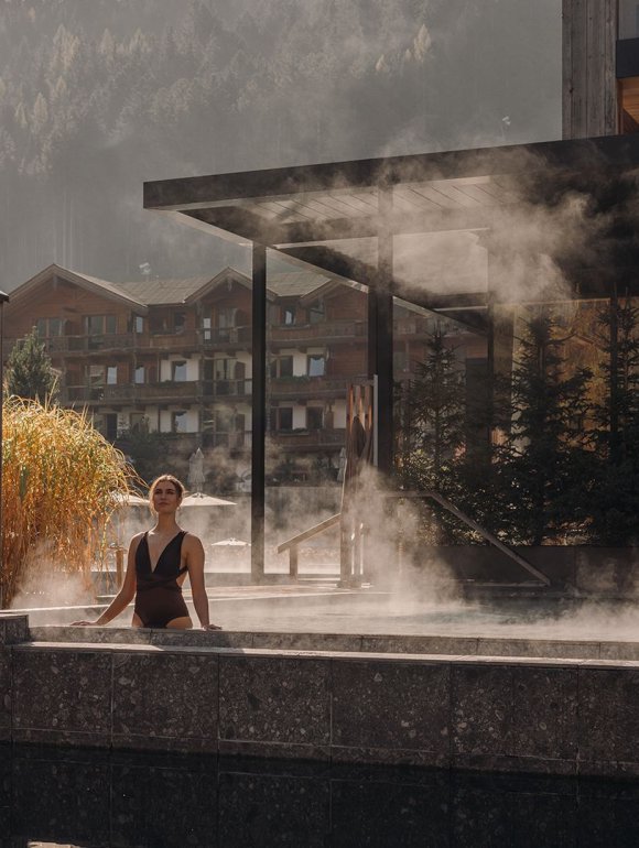 Gast genießt die Ruhe im warmen Seepool des Naturhotel Forsthofgut.