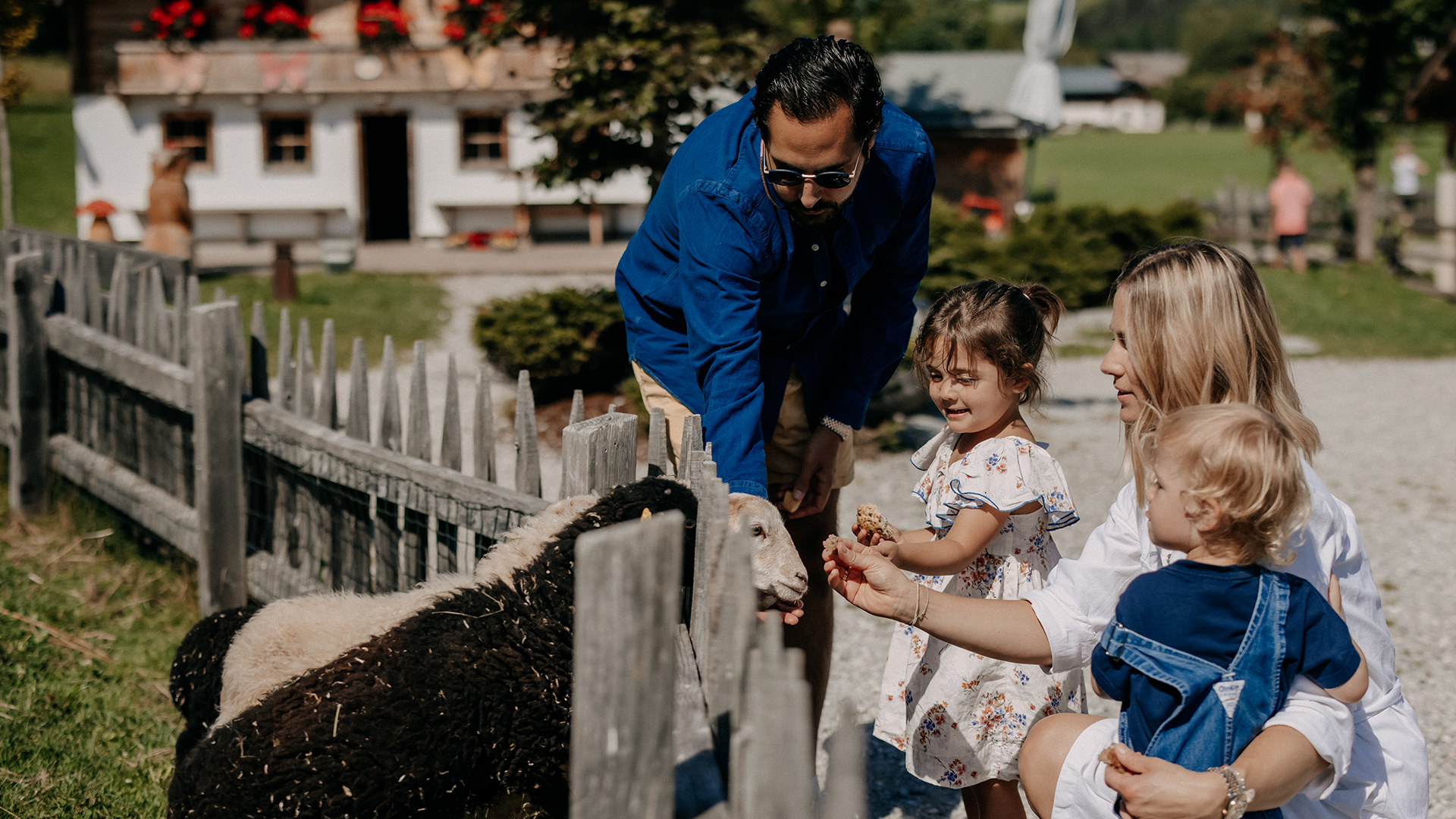 Familie mit Kindern füttert Ziegen im miniGUT des Forsthofguts.