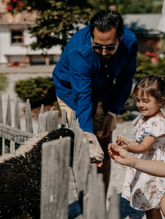 Familie mit Kindern füttert Ziegen im miniGUT des Forsthofguts.