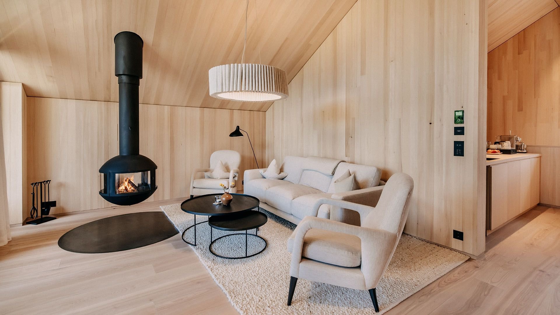 On the upper floor, there is a cozy seating area with a suspended fireplace.