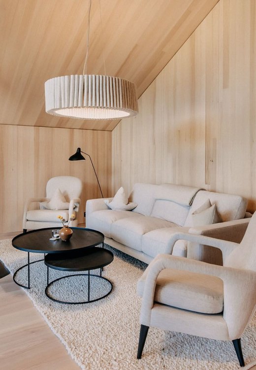 On the upper floor, there is a cozy seating area with a suspended fireplace.