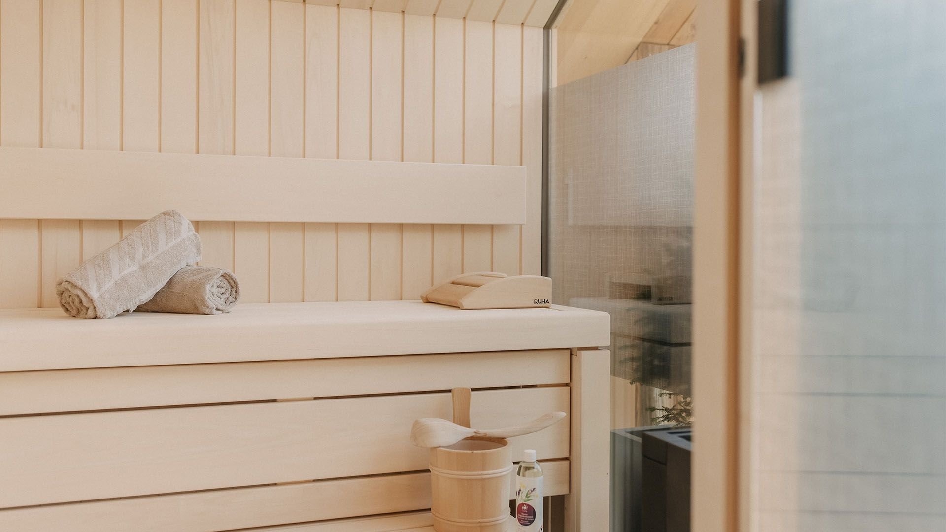 Close-up of a private sauna featuring a sauna bucket and ladle.