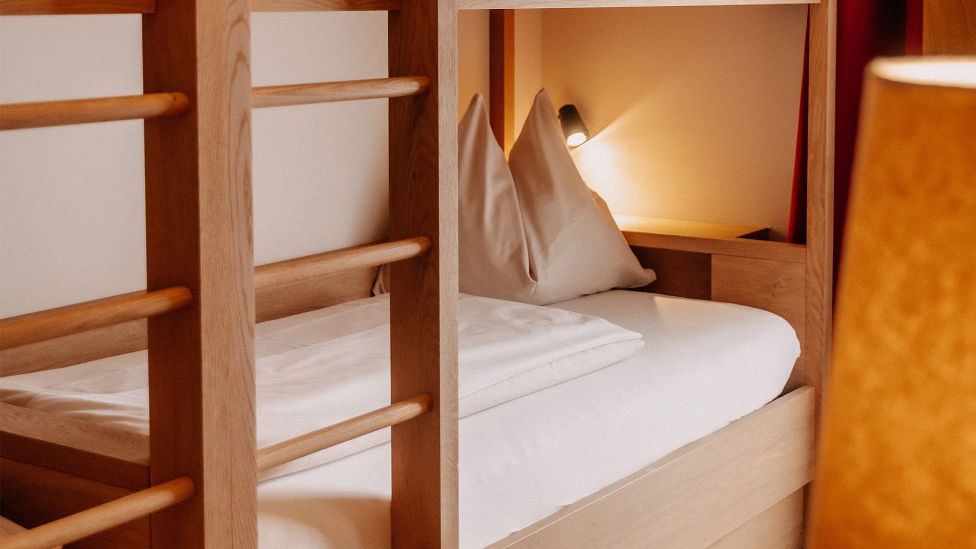 Close-up of a children's room featuring a bunk bed with a wall-mounted nightlight behind it.